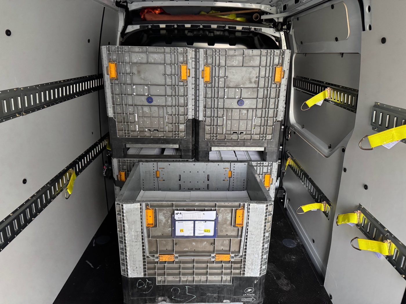 Conteneurs roulants de logistique postale chargés dans le fourgon